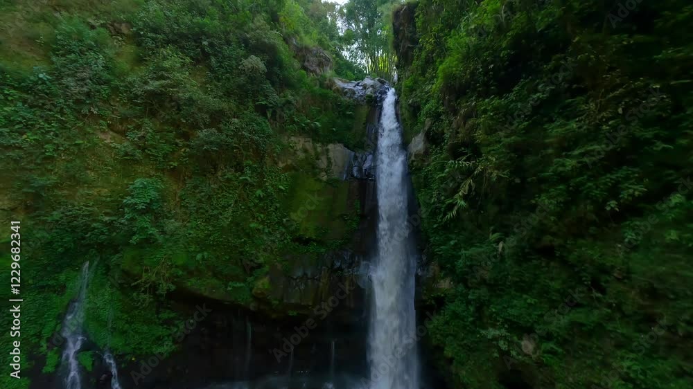 Cinematic FPV shot of tropical waterfall in the jungle in Central Java, Indonesia Cinematic FPV shot of tropical waterfall in the jungle in Central Java, Indonesia