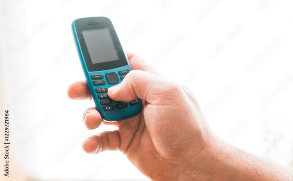Man hold a dumbphone. An old phone. Digital minimalism concept. Man hold a dumbphone. An old phone. Digital minimalism concept.