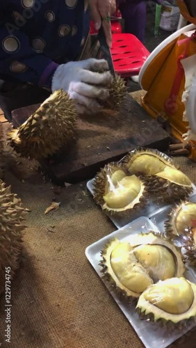 A woman sells durian fruit at a market