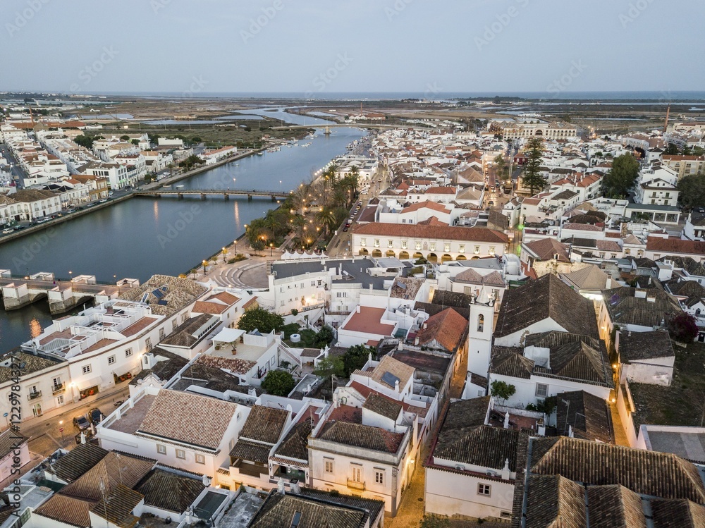 Obraz premium City view with roman bridge over Gilao river in old fishermen's town in the evening light, Tavira, drone shot, Algarve, Portugal, Europe