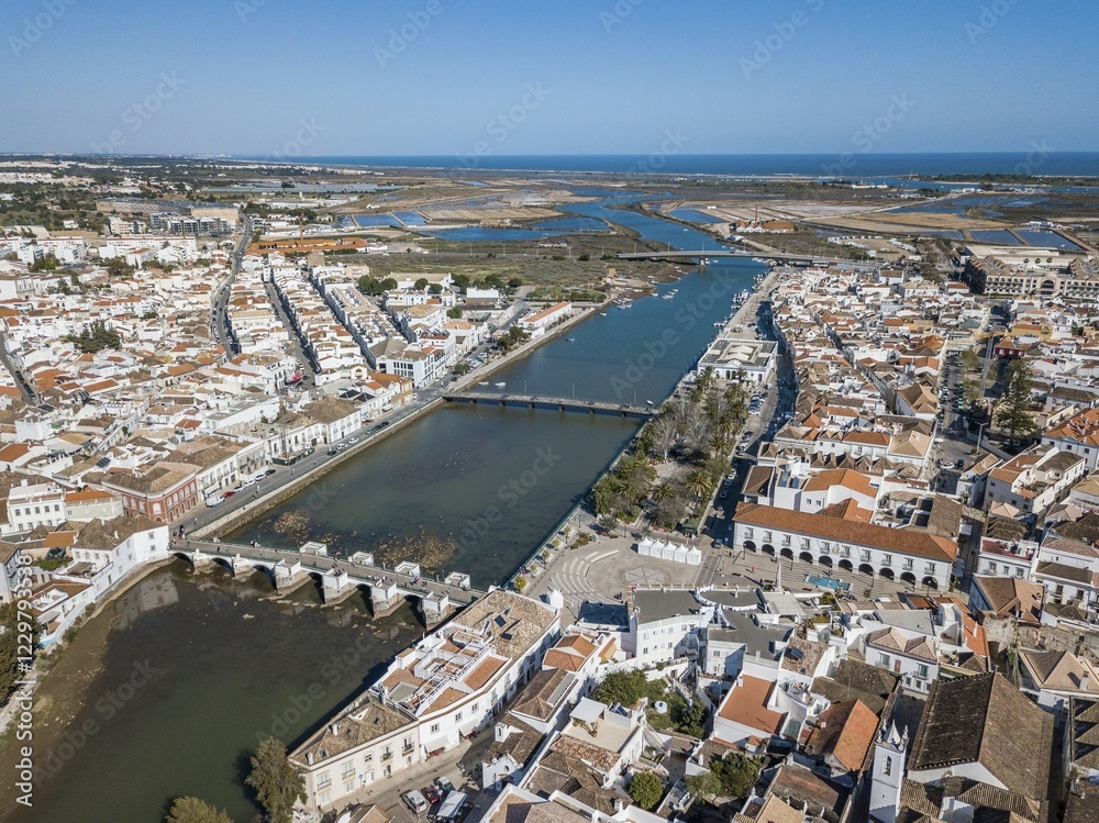 Fototapeta premium City view with roman bridge over Gilao river in old fishermen's town,Tavira, drone shot, Algarve, Portugal, Europe