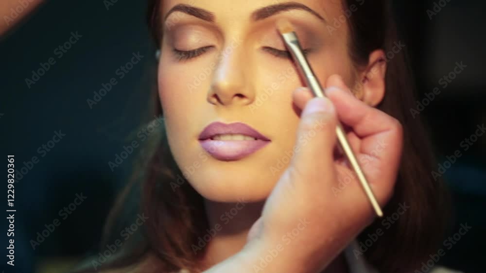 Makeup artist applying eyeshadow. Makeup beauty female eyes. Close-up eyeshadow make up face. Professional makeup artist with makeup model. Beautiful young woman with fashion eyeshadow. Makeup artist applying eyeshadow. Makeup beauty female eyes. Close-up eyeshadow make up face. Professional makeup artist with makeup model. Beautiful young woman with fashion eyeshadow.