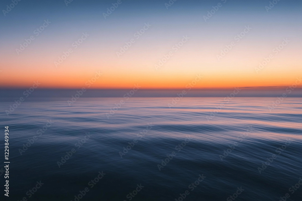 Fototapeta premium Sunset over calm ocean waters creates a serene atmosphere with vibrant colors on the horizon