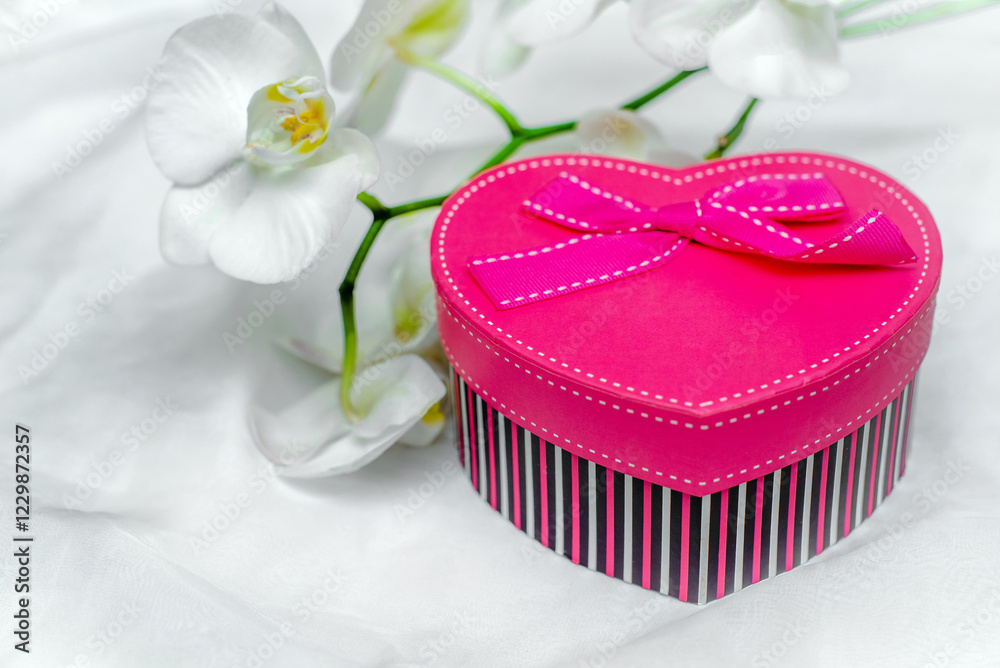 gift box in form of heart on the background of the white orchid gift box in form of heart on the background of the white orchid