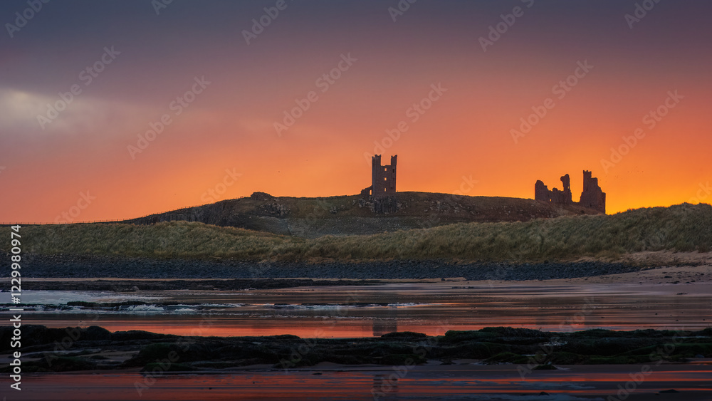 Obraz premium Sunrise over castle ruins Northumberland