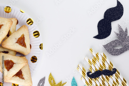 Close up freshly baked triangular cookies, adorned with light blue ribbons and decorated whiskers, tubes, masks on a white table. Purim celebration concept. top view photo