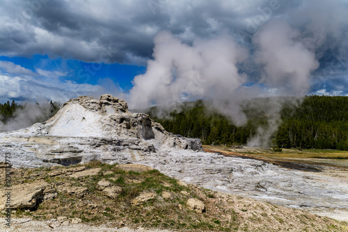 Geysers with hot water spew steam in Yellowstone National Park photo