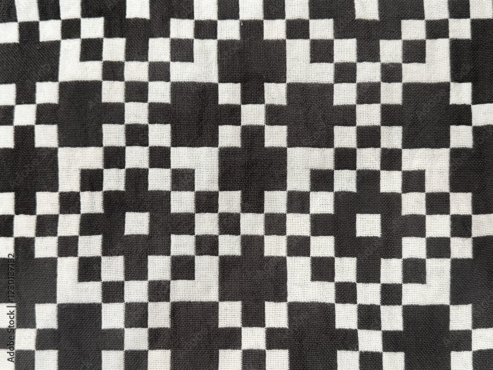 Fototapeta premium Fabric in random checkerboard pattern in black and white color. Checkered pattern with different square size. Seamless background texture.
