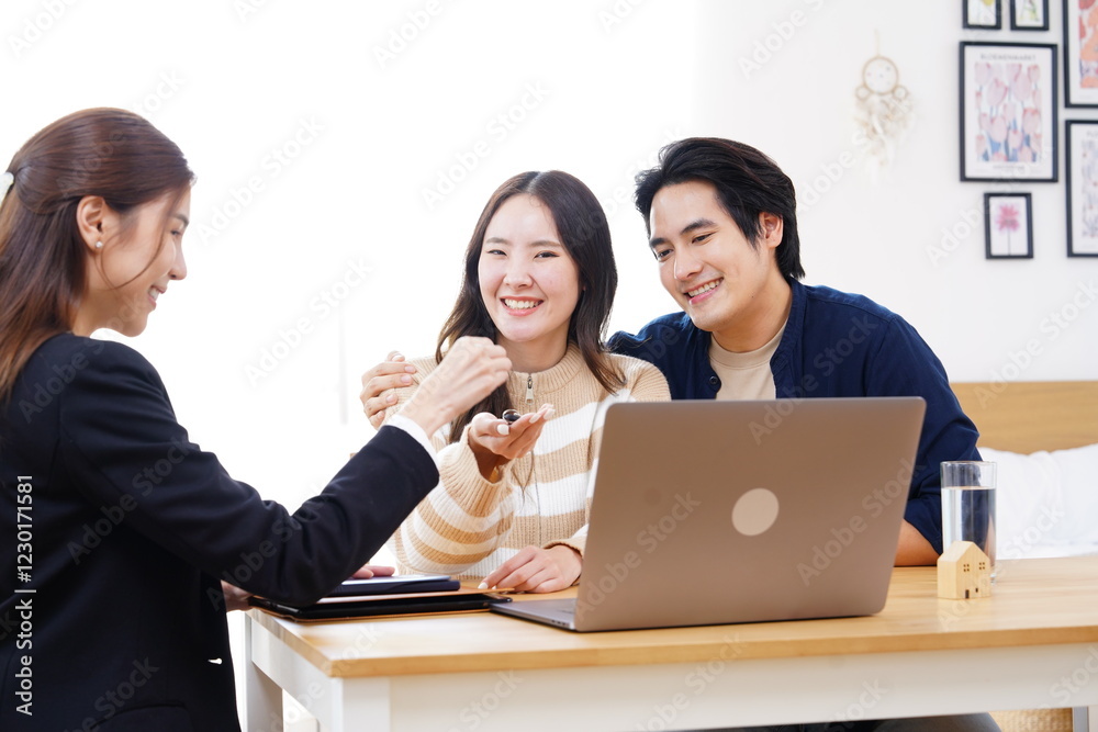 Saleswoman is Asian businesswoman broker shows condo house to Asian couple family happy want to buy new house agree to buy recommend loan and get key to new house. Saleswoman is Asian businesswoman broker shows condo house to Asian couple family happy want to buy new house agree to buy recommend loan and get key to new house.