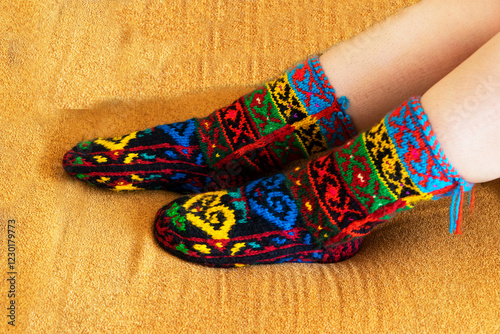 Beautiful wool socks made of multicolored threads on the girl's feet