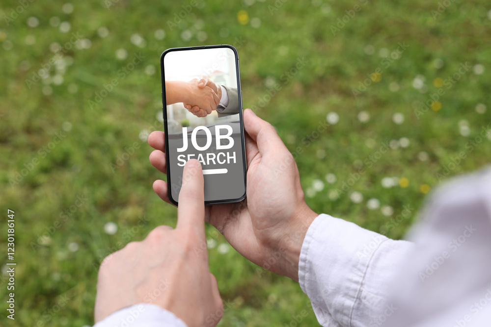 Man looking for job using employment website on mobile phone outdoors, closeup Man looking for job using employment website on mobile phone outdoors, closeup
