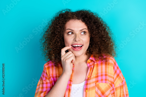 Smiling Fashionable Woman in Checkered Shirt against Teal Background Expressing Excited and Cheerful Feelings photo