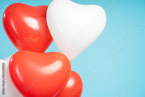 Red and white heart shaped balloons floating on light blue background