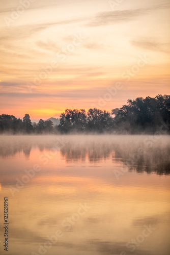 Sonnenaufgang über einem See mit mystischem Nebel photo