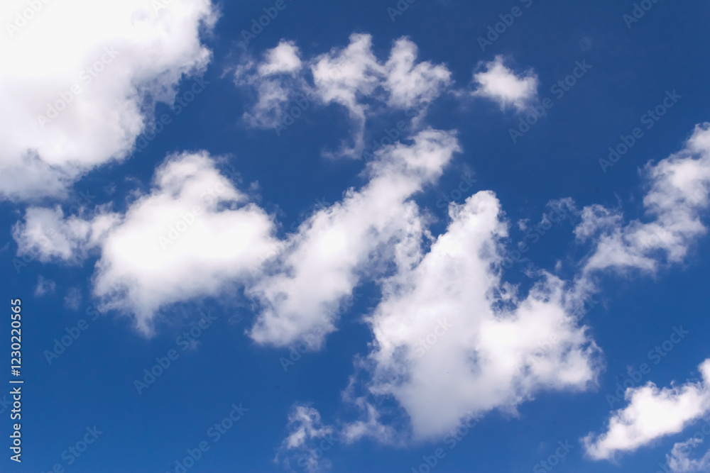 Fluffy white cumulus clouds floating gently over vibrant blue sky, representing peaceful atmospheric conditions with natural tranquility and meteorological beauty Fluffy white cumulus clouds floating gently over vibrant blue sky, representing peaceful atmospheric conditions with natural tranquility and meteorological beauty
