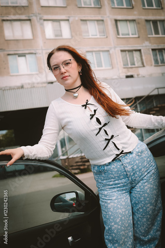 A young model in her 20s in light-colored jeans walks around the city. Mild spring weather. Local tourism.