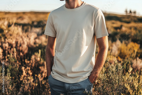 Close-up of a young man wearing a blank beige t-shirt with hands in pockets, perfect for showcasing your apparel design photo