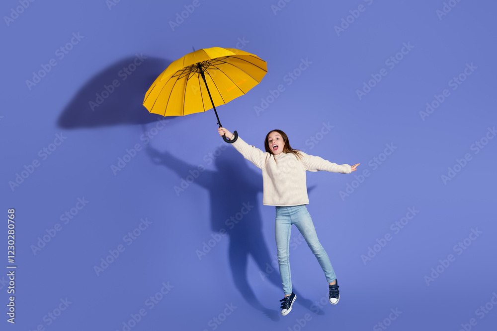 Young girl joyfully holding a yellow umbrella against a vibrant purple background, showcasing playful energy and colorful style Young girl joyfully holding a yellow umbrella against a vibrant purple background, showcasing playful energy and colorful style