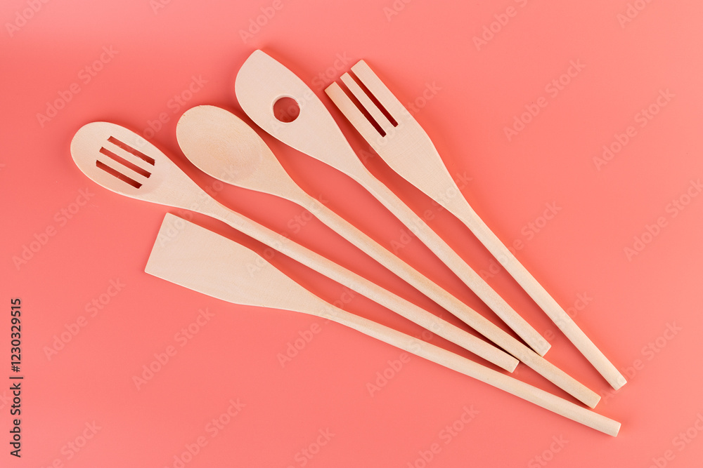 close-up on soft pink background lie new kitchen light wooden utensils of different shapes spatulas for tephlon coating natural wood handmade different types of use close-up on soft pink background lie new kitchen light wooden utensils of different shapes spatulas for tephlon coating natural wood handmade different types of use