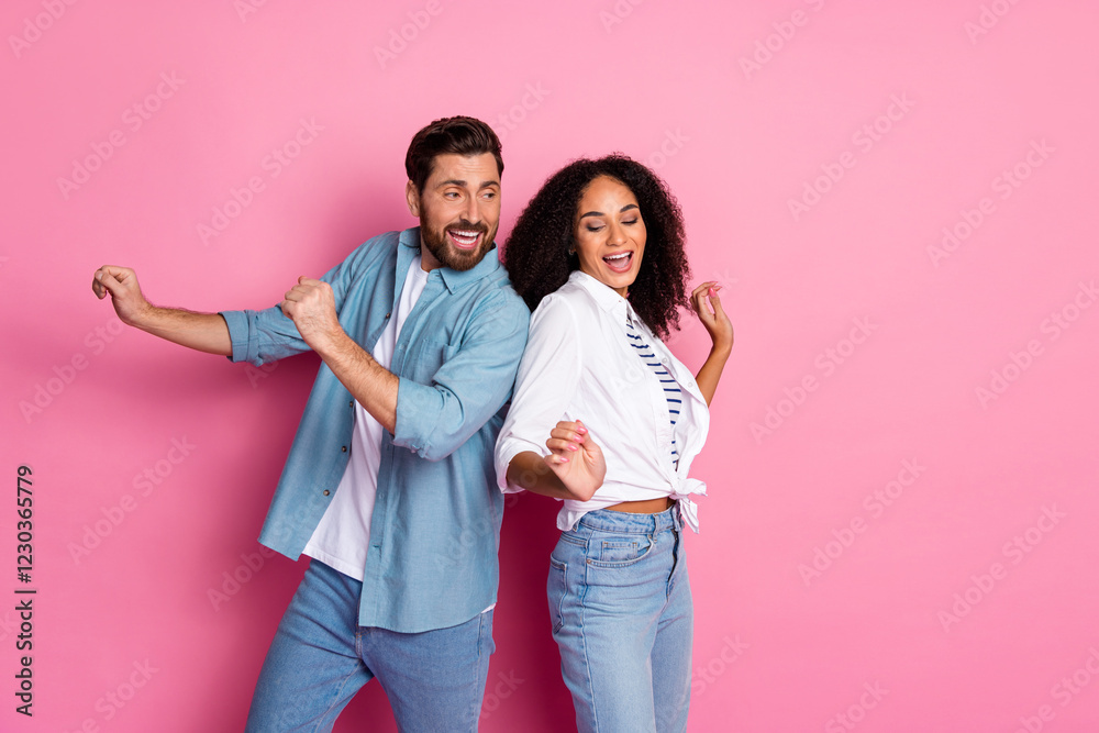 Fototapeta premium Two happy young people enjoying a funny moment against a pink background