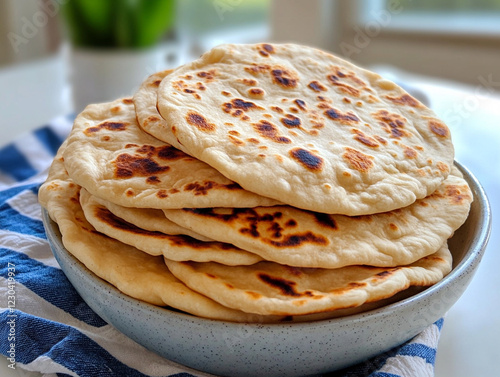 Freshly made flatbreads on a table with a striped cloth photo