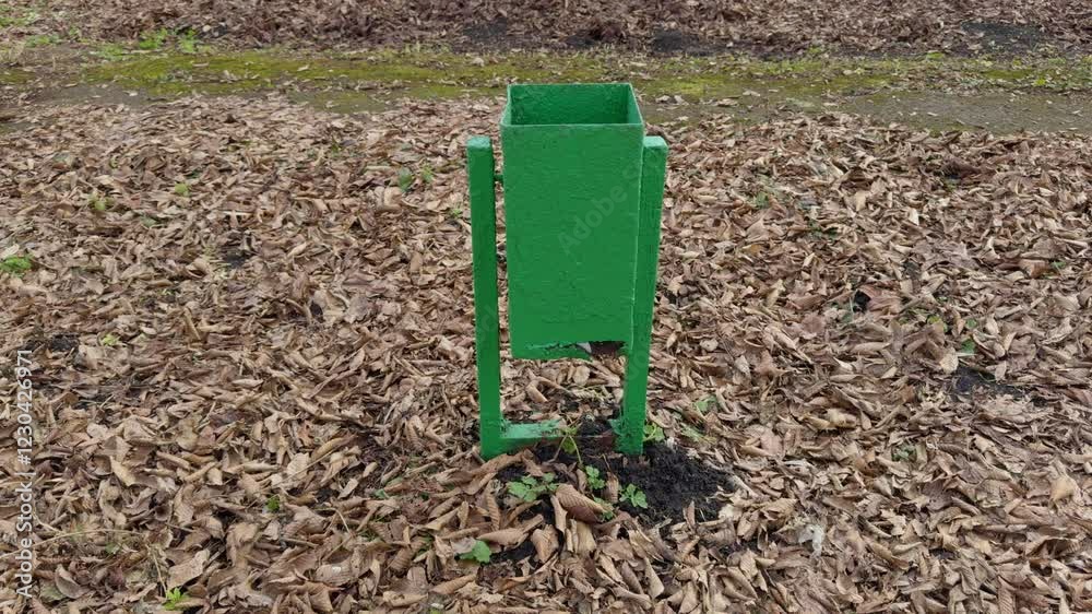The janitor inserts a garbage bag into the trash can. trash can in the park The janitor inserts a garbage bag into the trash can. trash can in the park