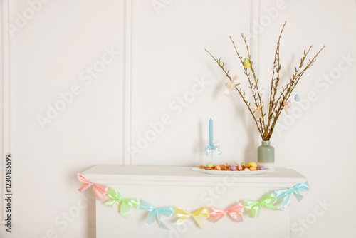 Easter background, fireplace decorated with colorful ribbons, willow bouquet, painted eggs and candlestick with copy space photo