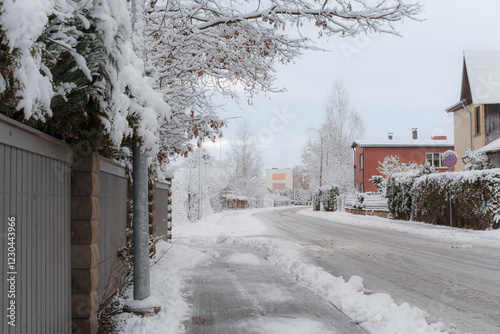 Fototapeta Naklejka Na Ścianę i Meble -  Small town street in winter in Latvia with piles of ice and snow