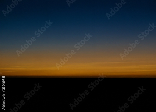 Ein subtiler Übergang von Gold zu zartem Blau, als ob der Himmel gerade von den ersten Sonnenstrahlen erleuchtet wird photo