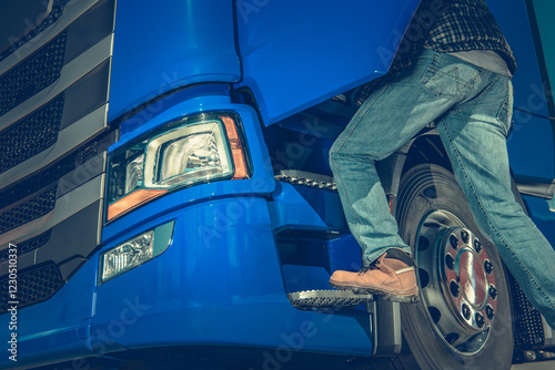 Worker Climbs Into Blue Semi Truck During Daylight at a Loading Dock photo