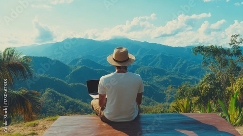 Young man freelancer traveler wearing hat anywhere working online using laptop and enjoying mountains view