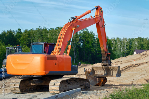 Obraz na płótnie Tracked excavator working on suburban road construction project, preparing foundation for new bridge, infrastructure development for road project w salonie