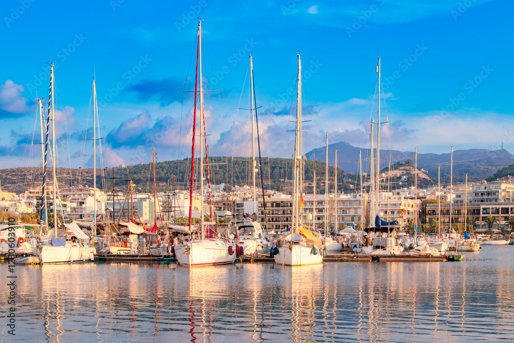 Greece. Rethymnon. Beautiful cityscape port, arsenal, modern buildings, yachts, azure sea water on the background of stormy sky at evening, harbor.