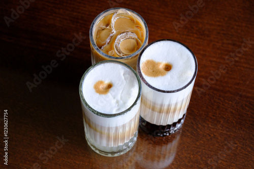 Three iced coffee drinks with varying levels of milk and foam