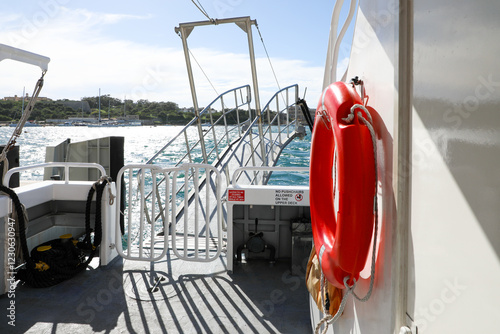 The sunlit gangway is prepared for disembarking passengers from a sea vessel onto the pier.