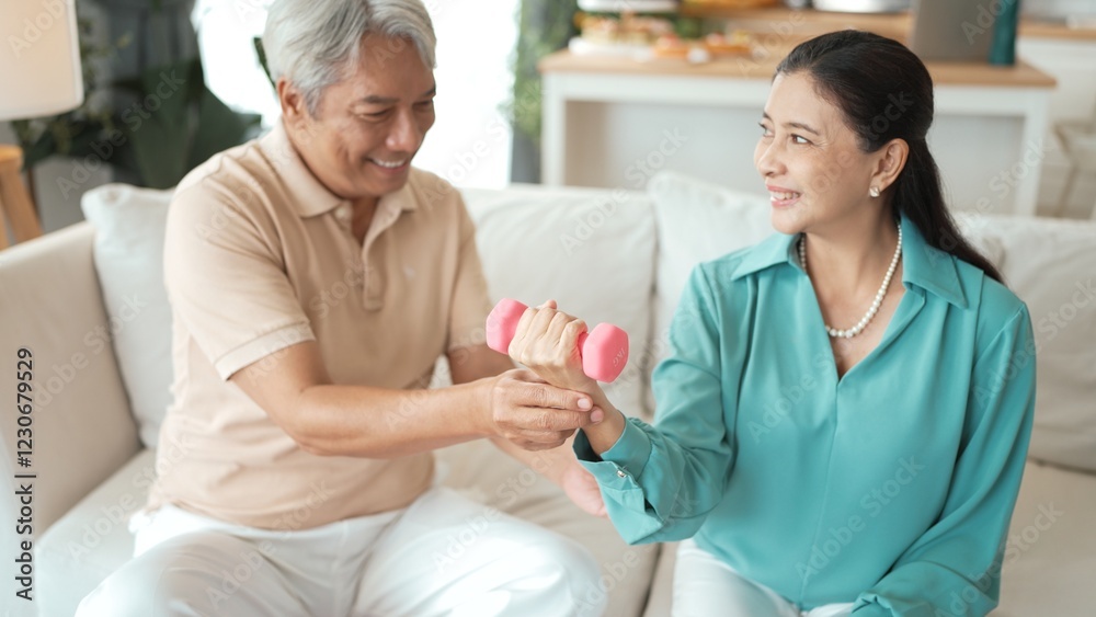 Happy elderly couple exercising together with dumbbells at home, focusing on muscle strength, joint health, and physical wellness for improved mobility and healthy aging. Retirement concept. Myrmidon. Happy elderly couple exercising together with dumbbells at home, focusing on muscle strength, joint health, and physical wellness for improved mobility and healthy aging. Retirement concept. Myrmidon.