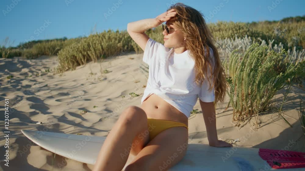 Sexy surf girl sitting sand in front sky wearing bikini. Lady relaxing beach
