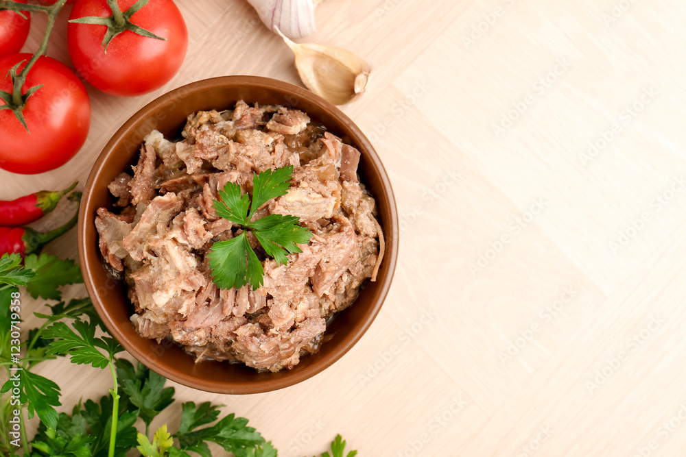 Canned meat in bowl, parsley, tomatoes and garlic on wooden table, top view. Space for text
