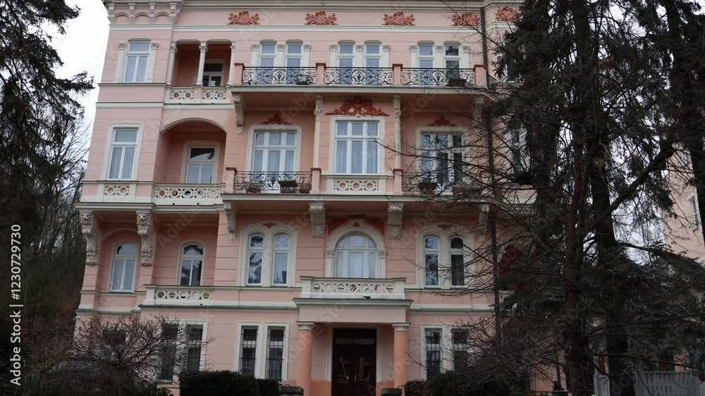 The camera showcases a beautifully crafted pink building with ornate ...
