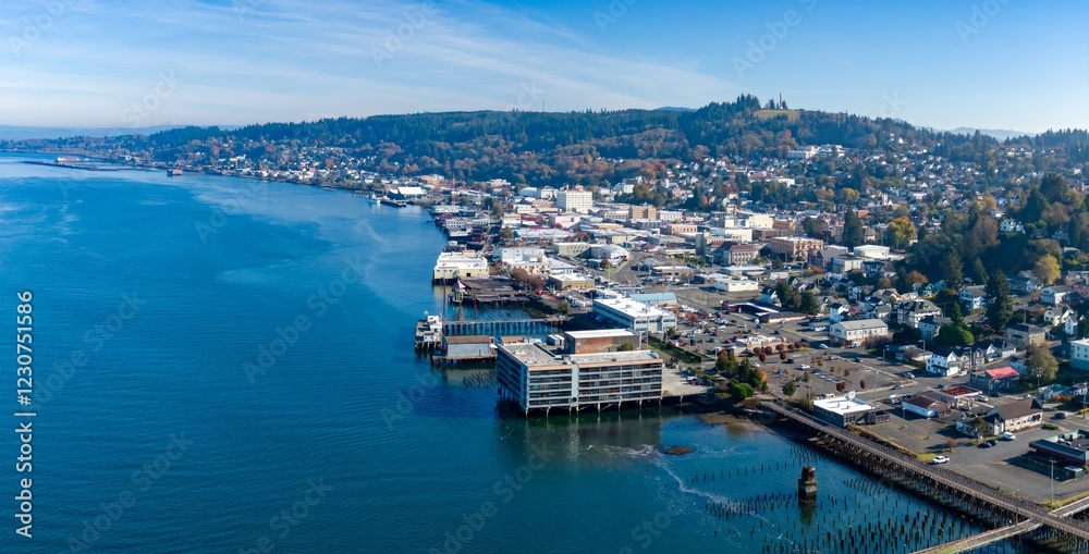 Fototapeta premium High-angle view of Astoria, Oregon, showcasing the city's waterfront and surrounding hills. Buildings line the Columbia River, Oregon, USA