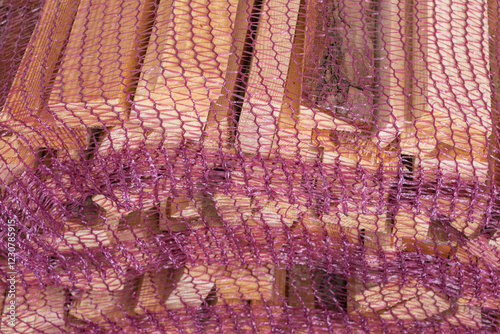 Seasoned kindling wood pieces in a net bag for lighting wood stoves and fireplaces