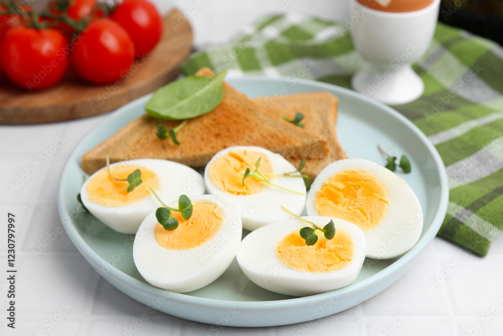 Cut hard boiled eggs with bread on white tiled table, closeup Cut hard boiled eggs with bread on white tiled table, closeup