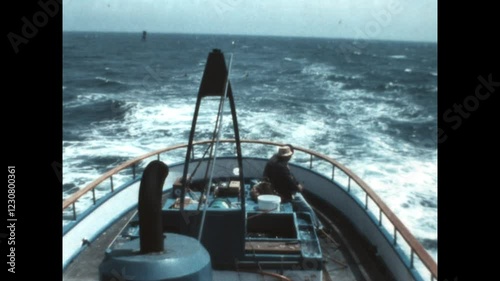 Riding in the Stern 1976 - Two men sit in the stern of a fishing boat as it plies choppy waters off of the coast of Long Beach, California in 1976. 