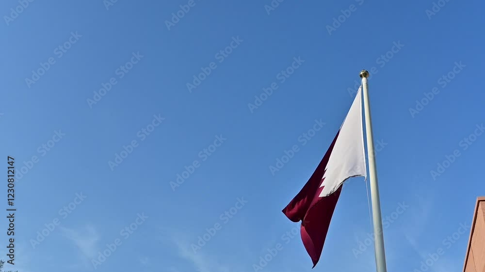 Qatar flag waving in the wind and blue sky