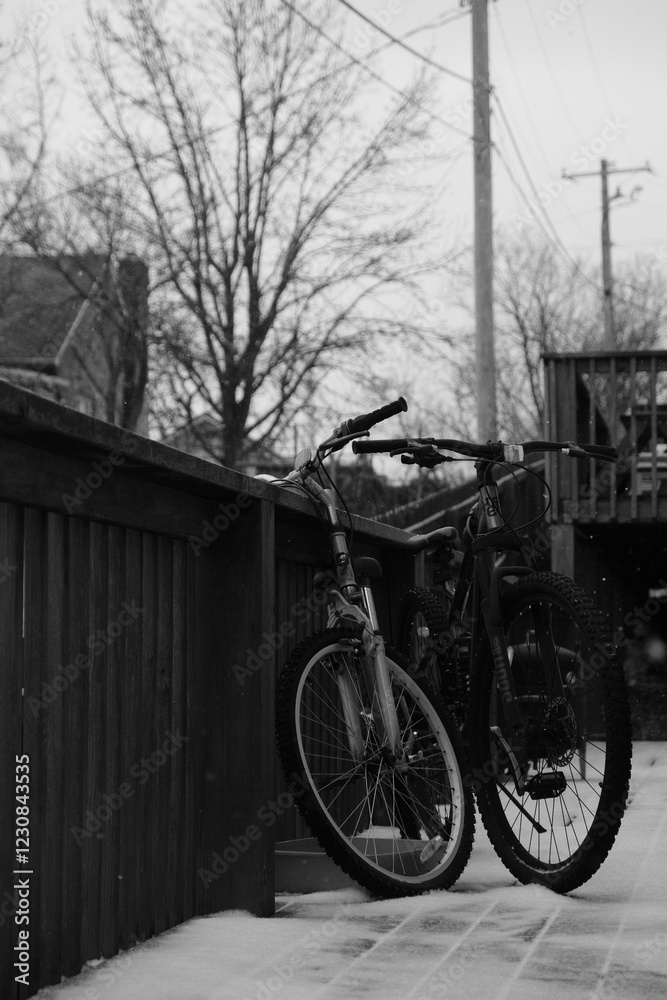Bicycles Resting by Snow-Dusted Wooden Railing in Winter Scene Bicycles Resting by Snow-Dusted Wooden Railing in Winter Scene