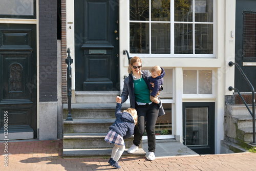 Mother and small children left the house for a walk or to kindergarten or school in Amsterdam.