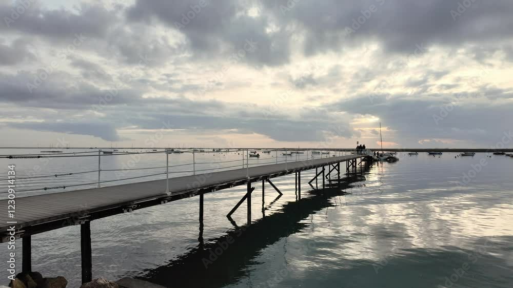 looking out to the water from faro, portugal, on a cloudy day after sunset, with the sun peaking through the clouds. looking out to the water from faro, portugal, on a cloudy day after sunset, with the sun peaking through the clouds.