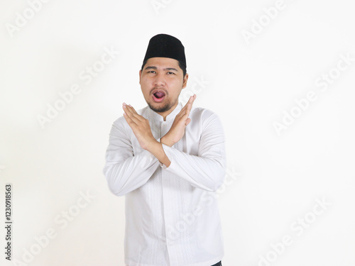 Asian Muslim man shows a prohibitive gesture with crossed arms. concept of Islamic religious people in the context of the month of Ramadan and Eid Mubarak