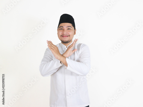 Asian Muslim man shows a prohibitive gesture with crossed arms. concept of Islamic religious people in the context of the month of Ramadan and Eid Mubarak