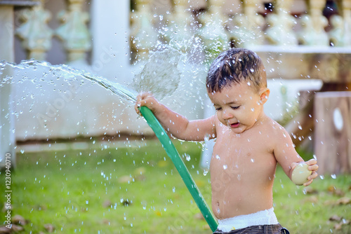 child playing with water, child playing in the garden, child playing, boy playing, one year old, boy playing with water in the garden, water in the hose